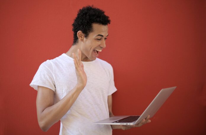 cheerful man using laptop for video call