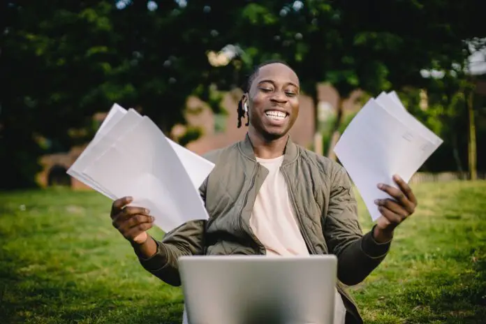 student with documents and laptop happy about getting into university