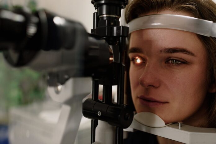 woman sitting at slit lamp